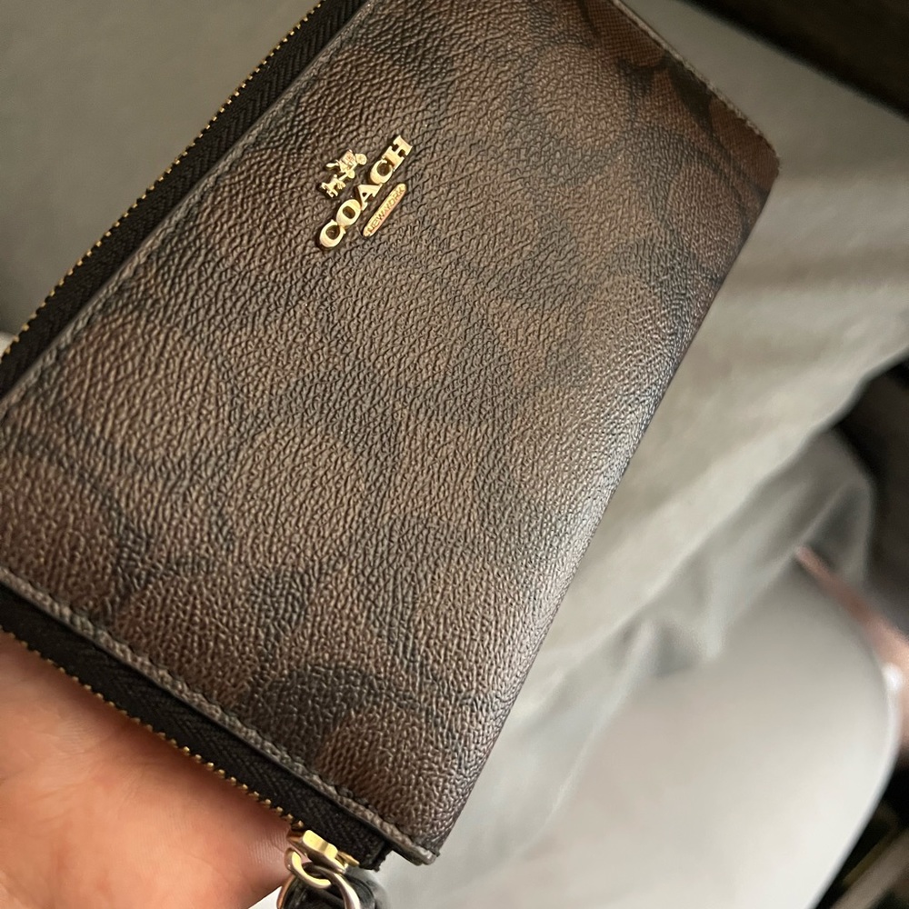 Brown Coach zip around phone wallet with wrist strap